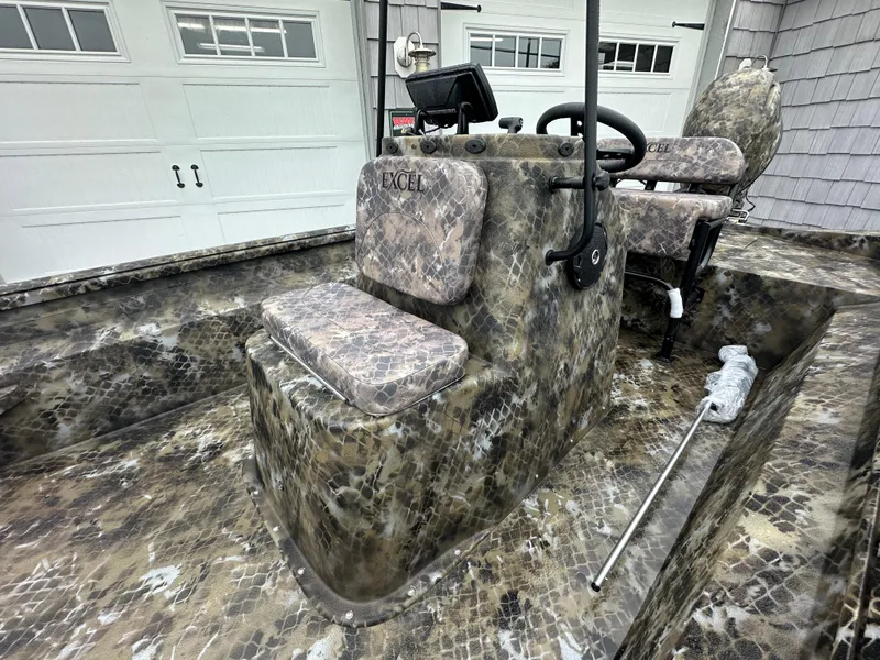 Slide: The Image of 2025 Excel 1960 Stalker CC camo boat interior with steering console and seats. - 13