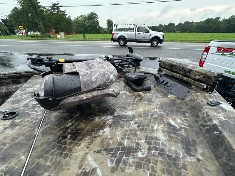 Slide: The Image of 2025 Excel 1960 Stalker CC boat with camo seats and equipment on a rainy day. - 15