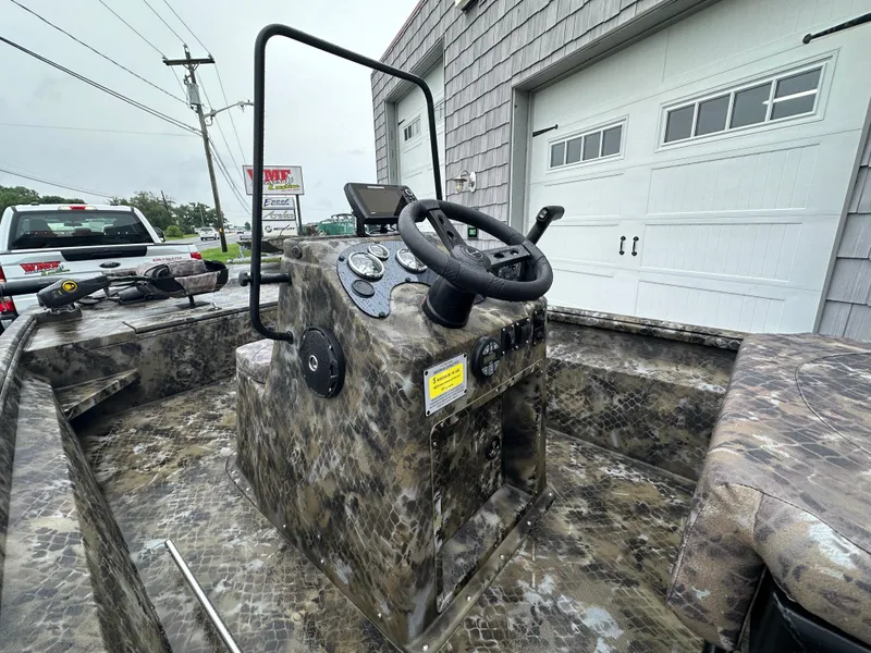 Slide: The Image of 2025 Excel 1960 Stalker CC boat console with camouflage design, steering wheel, and controls. - 17