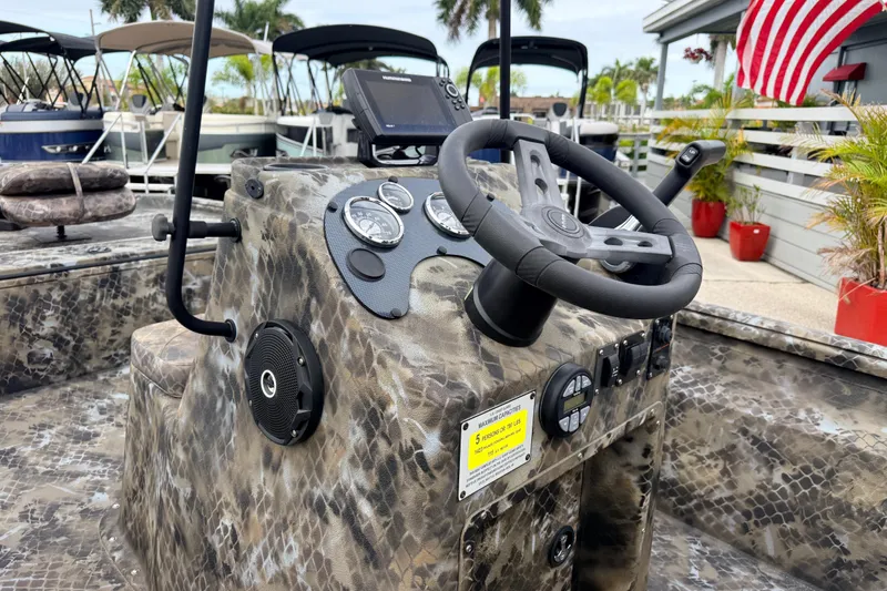 Slide: The Image of Camouflage-patterned dashboard of 2025 Excel 1960 Stalker CC boat with steering wheel and gauges. - 34