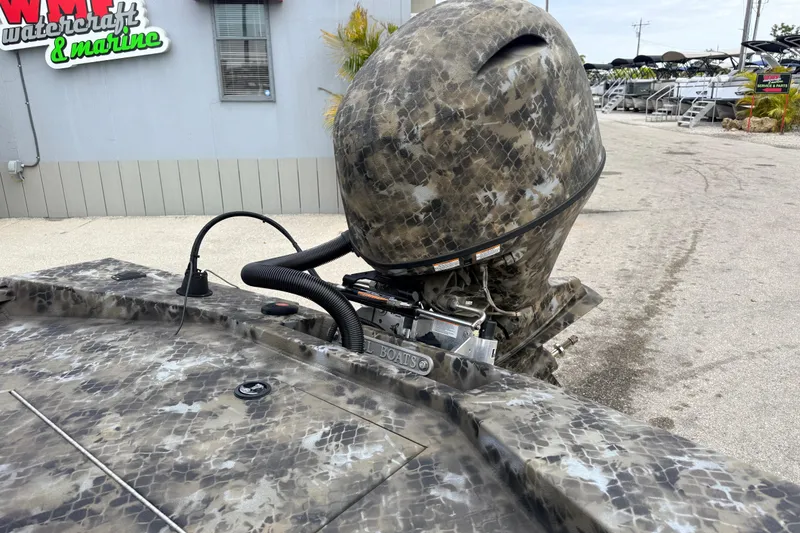 Slide: The Image of Camouflage-patterned 2025 Excel 1960 Stalker CC boat with outboard motor at marine dealership. - 36