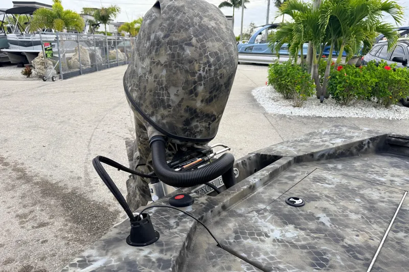 Slide: The Image of 2025 Excel 1960 Stalker CC boat with camouflage pattern, parked outdoors. - 42