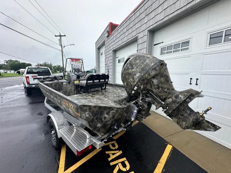 Slide: The Image of 2025 Excel 1960 Stalker CC boat on trailer outside a garage. - 5