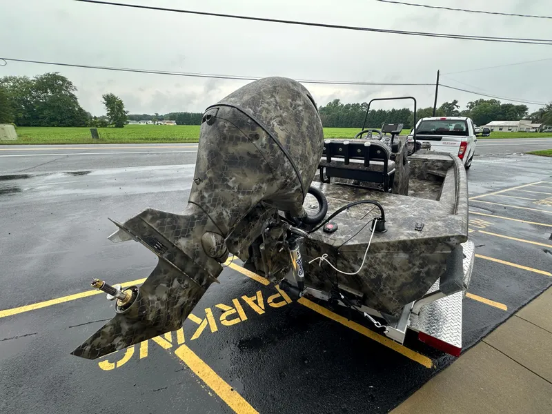 Slide: The Image of 2025 Excel 1960 Stalker CC boat with camo design on trailer in parking lot. - 6