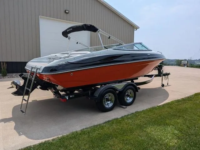 Slide: The Image of 2013 Crownline 21 SS boat on trailer, parked outside a large building. - 3
