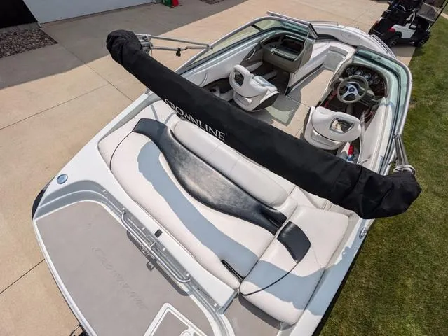 Slide: The Image of 2013 Crownline 21 SS boat with sleek interior and steering wheel, parked on driveway. - 6