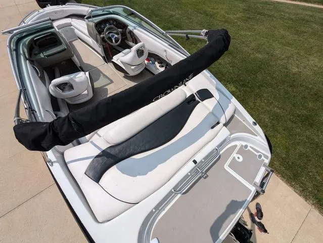 Slide: The Image of 2013 Crownline 21 SS boat interior with seating and steering wheel, parked on concrete. - 7
