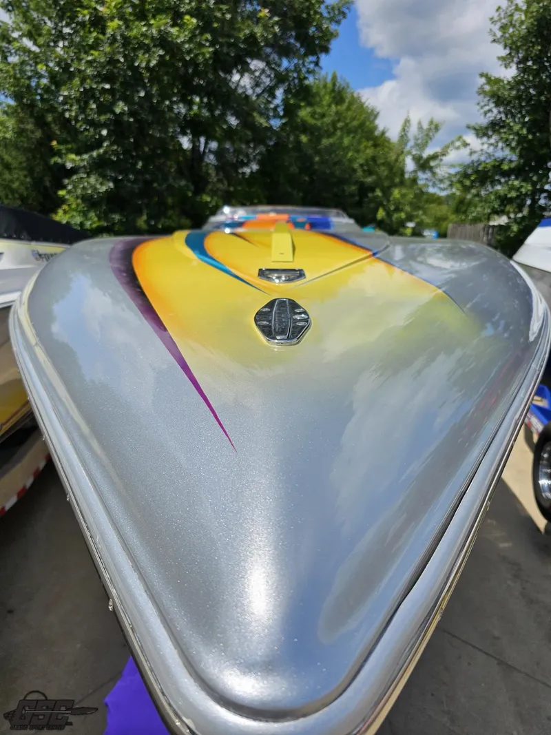 Slide: The Image of 2004 Outerlimits 42 Legacy speedboat with vibrant paint design, docked outdoors. - 28