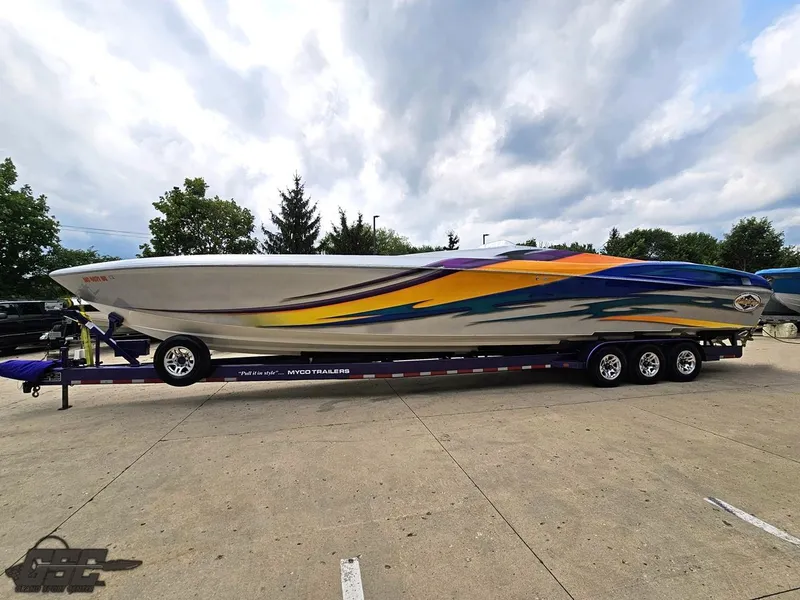 Slide: The Image of 2004 Outerlimits 42 Legacy powerboat on a trailer with vibrant graphics. - 32