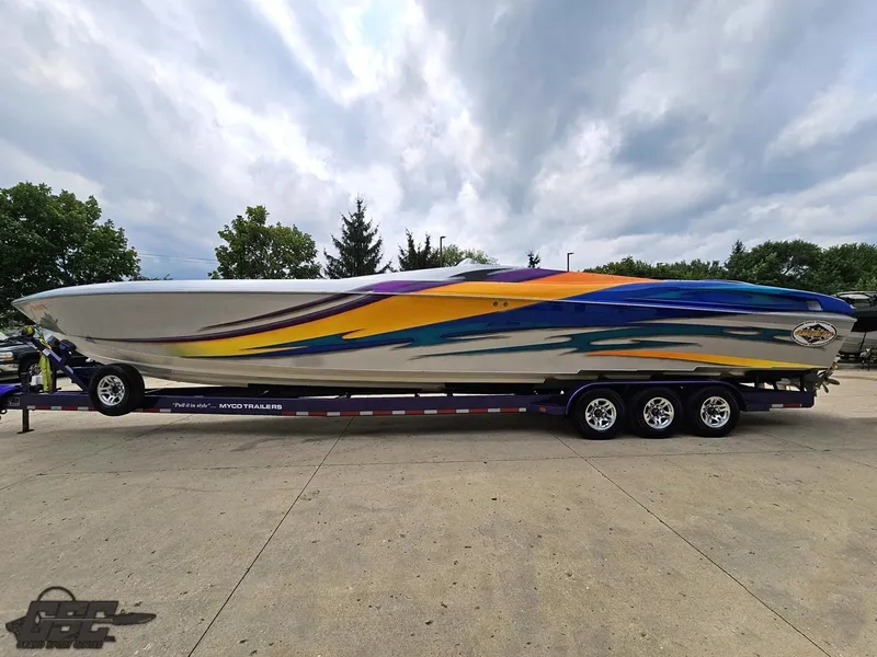 Slide: The Image of 2004 Outerlimits 42 Legacy speedboat with vibrant graphics on a triple-axle trailer. - 33