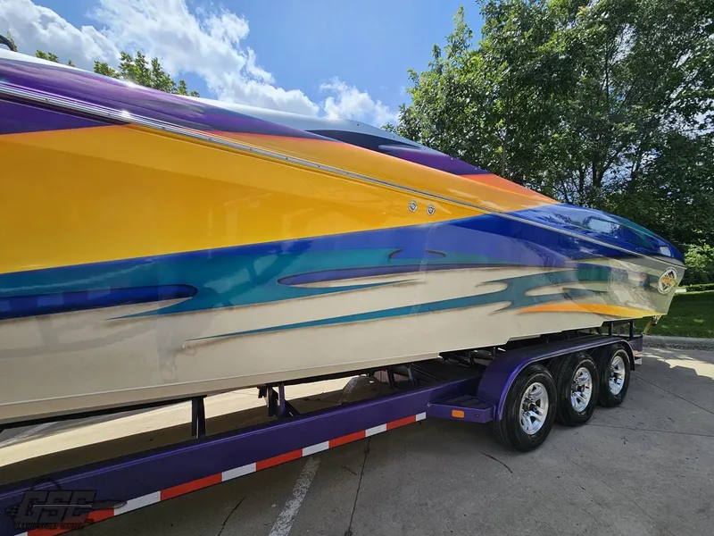 Slide: The Image of 2004 Outerlimits 42 Legacy speedboat with vibrant, colorful design on a triple-axle trailer. - 34