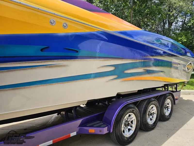 Slide: The Image of 2004 Outerlimits 42 Legacy speedboat with vibrant custom paint on a triple-axle trailer. - 35