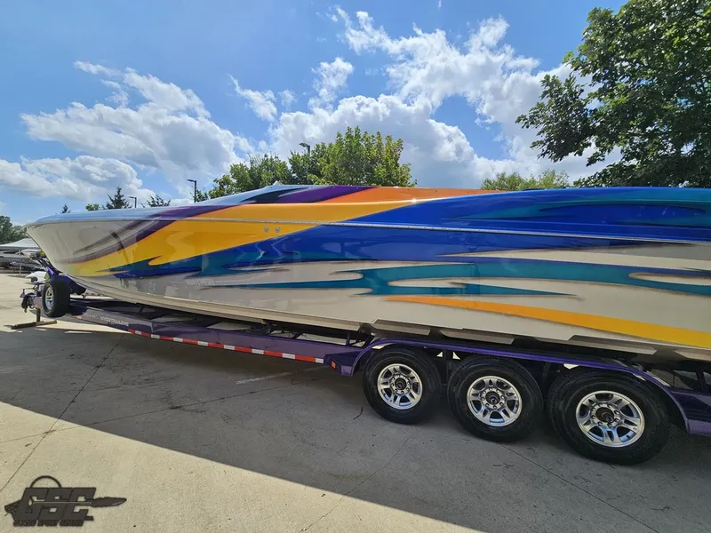 Slide: The Image of 2004 Outerlimits 42 Legacy speedboat on a trailer, featuring vibrant blue, yellow, and purple graphics. - 40