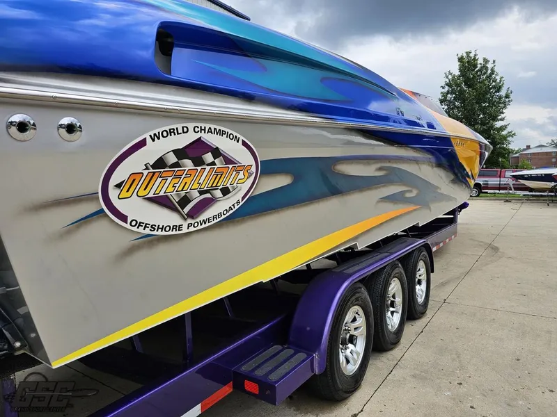 Slide: The Image of 2004 Outerlimits 42 Legacy powerboat on a trailer, showcasing vibrant graphics. - 47