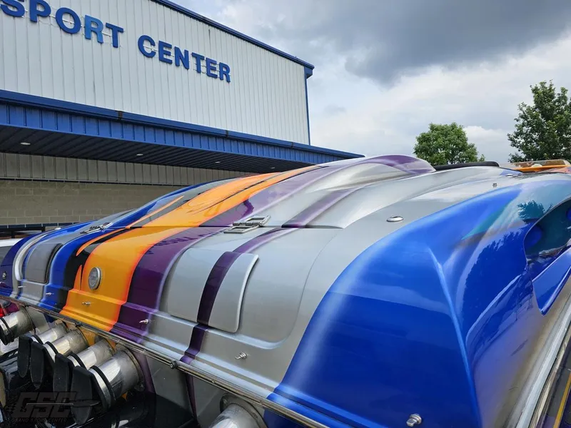 Slide: The Image of 2004 Outerlimits 42 Legacy boat with vibrant custom paint at a sport center. - 48