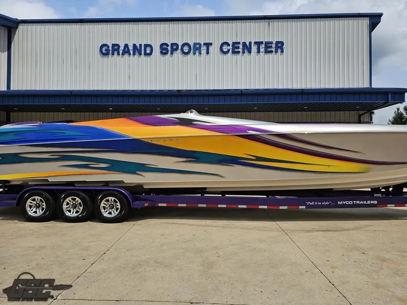 Slide: The Image of 2004 Outerlimits 42 Legacy boat with vibrant graphics at Grand Sport Center. - 5