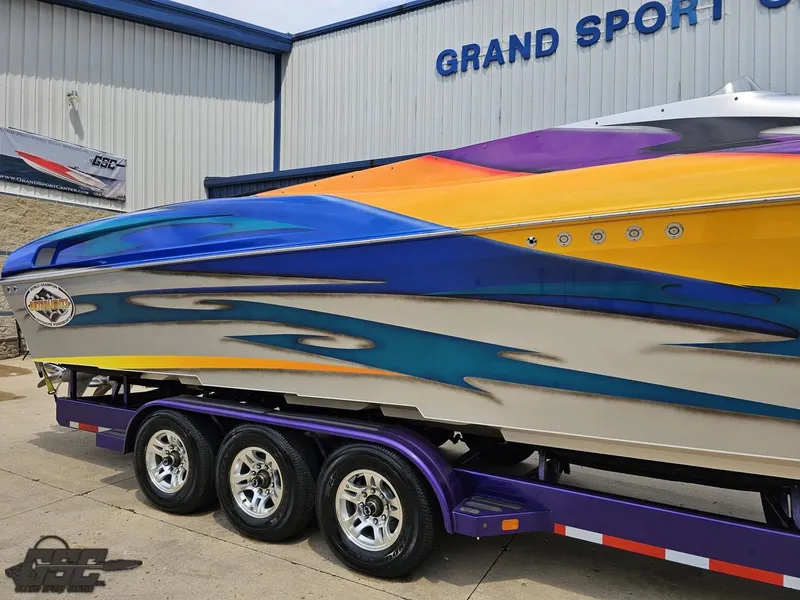 Slide: The Image of 2004 Outerlimits 42 Legacy speedboat with vibrant custom paint on a triple-axle trailer. - 8