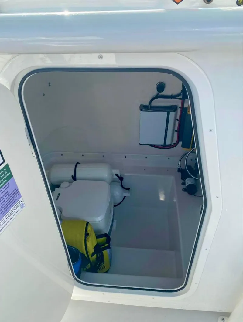 Slide: The Image of 2022 Parker 2801 Center Console boat storage compartment with safety equipment. - 13
