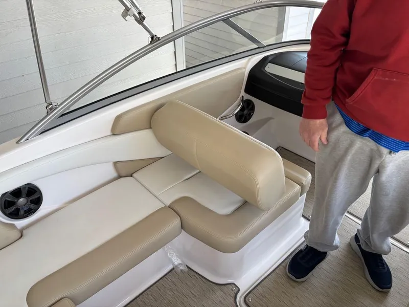 Slide: The Image of 2017 Regal 1900 ES boat interior with beige seating and a person standing nearby. - 10