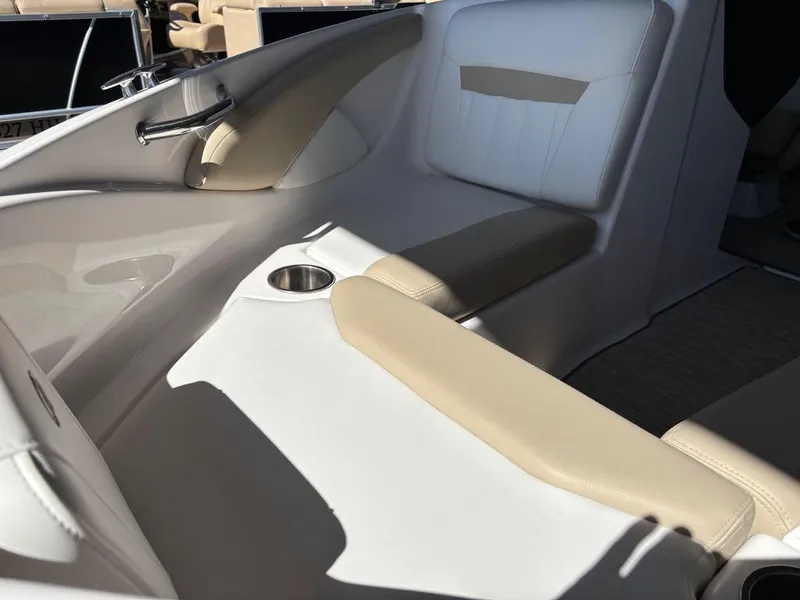 Slide: The Image of 2017 Regal 1900 ES boat interior with beige and white seating, cup holder, and chrome handle. - 13