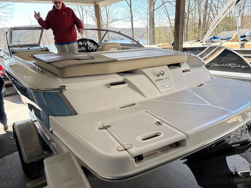 Slide: The Image of 2017 Regal 1900 ES boat on trailer under shelter, person standing nearby. - 16