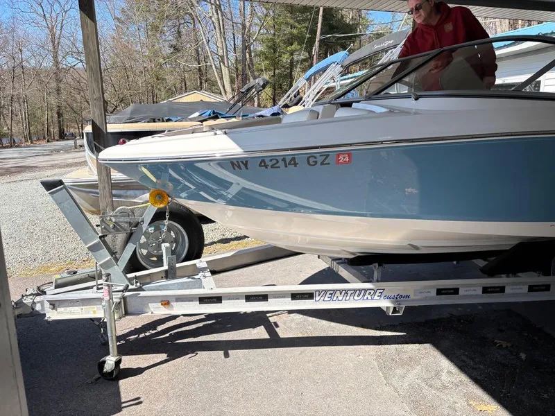 Slide: The Image of 2017 Regal 1900 ES boat on trailer, parked outdoors, with trees in the background. - 5