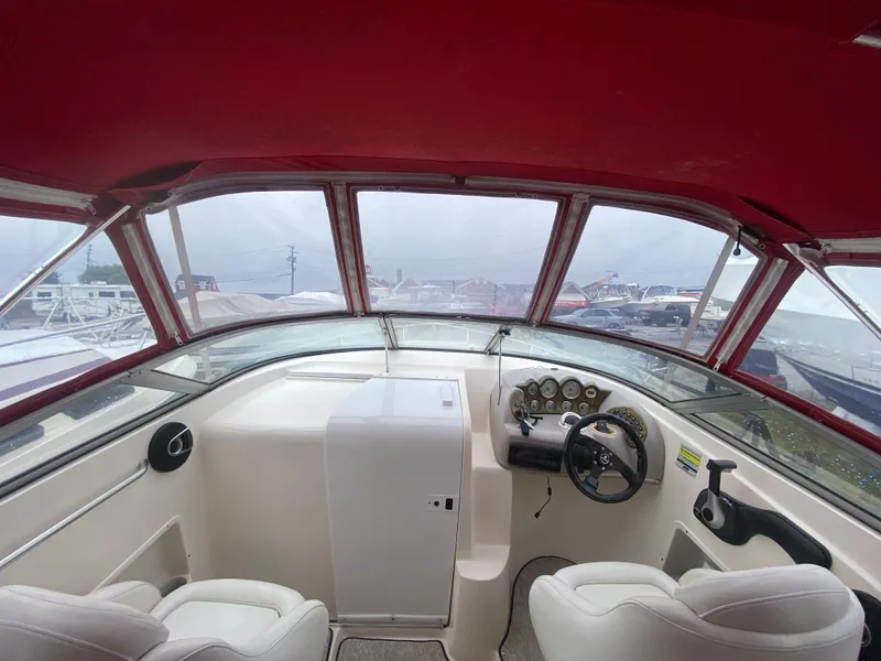 Slide: The Image of Interior view of 2005 Rinker 232 Captiva Cuddy boat cockpit with red canopy. - 15