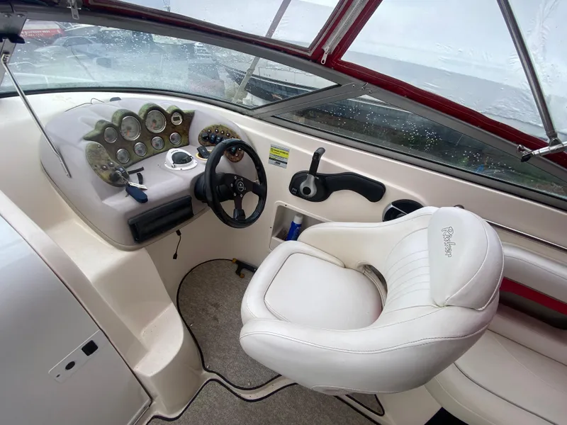 Slide: The Image of 2005 Rinker 232 Captiva Cuddy boat cockpit with steering wheel and control panel. - 17