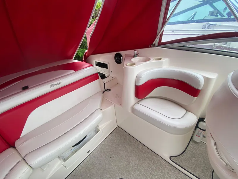 Slide: The Image of Interior of 2005 Rinker 232 Captiva Cuddy boat with red and white seating. - 13