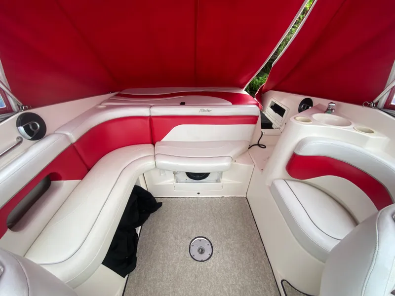 Slide: The Image of Interior of 2005 Rinker 232 Captiva Cuddy boat with red and white seating. - 14