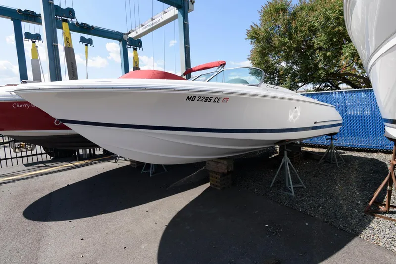 The Image of 2001 Chris-Craft Launch 22 boat on stands, white hull, outdoor display. - 0