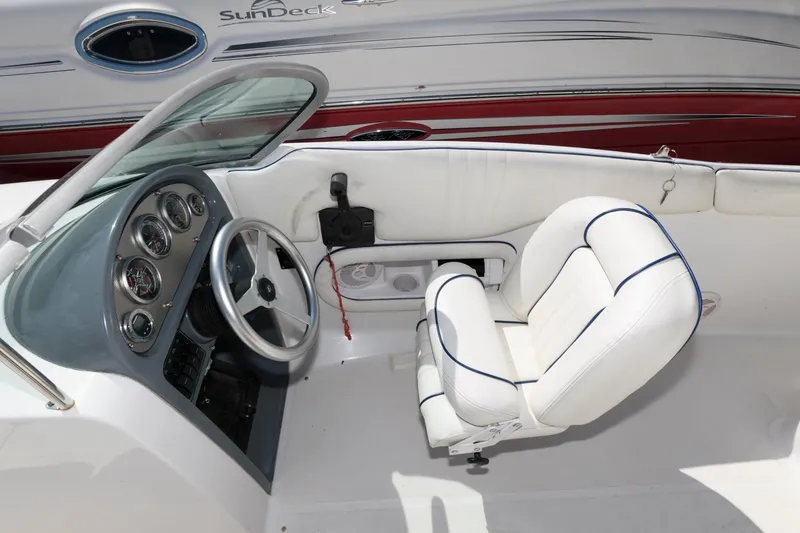 Slide: The Image of 2001 Chris-Craft Launch 22 boat interior with white seating and dashboard controls. - 9