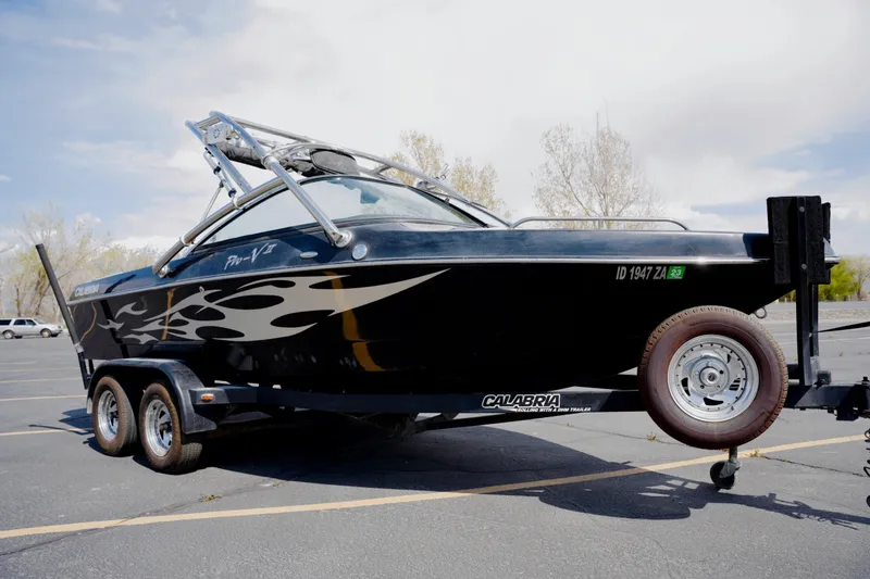Slide: The Image of 2007 Calabria PVO-V2 boat on trailer, black with flame design, parked outdoors. - 5