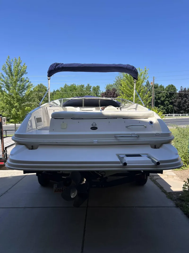 Slide: The Image of 2001 Rinker Captiva 232 boat with canopy, parked on driveway. - 4