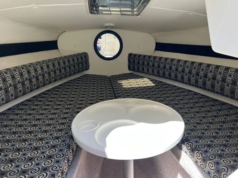 Slide: The Image of Interior cabin of 2001 Rinker Captiva 232 boat with patterned seating and round table. - 9