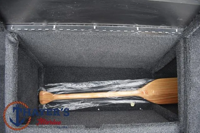 Slide: The Image of 2024 Tracker Pro 170 storage compartment with wooden paddle. - 18