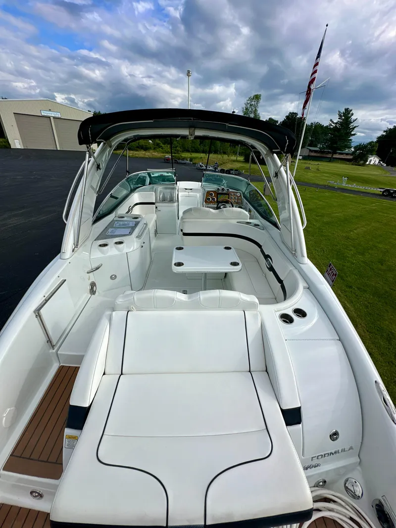 Slide: The Image of 2008 Formula 310 Bowrider boat with spacious seating and sleek design, docked outdoors. - 1