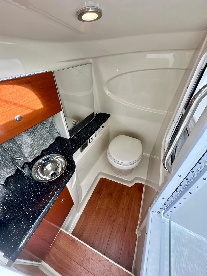 Slide: The Image of 2008 Formula 310 Bowrider bathroom with sink, toilet, and wood flooring. - 13