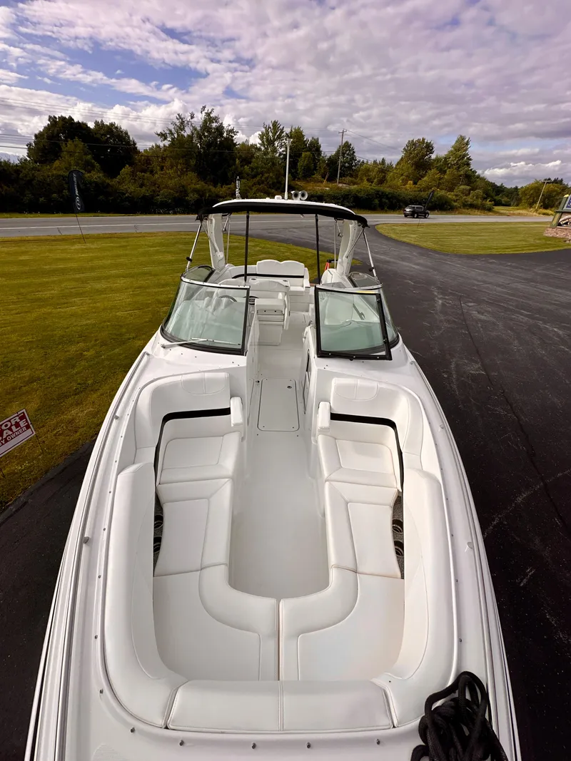 Slide: The Image of 2008 Formula 310 Bowrider boat with spacious seating, parked on a driveway under a cloudy sky. - 18