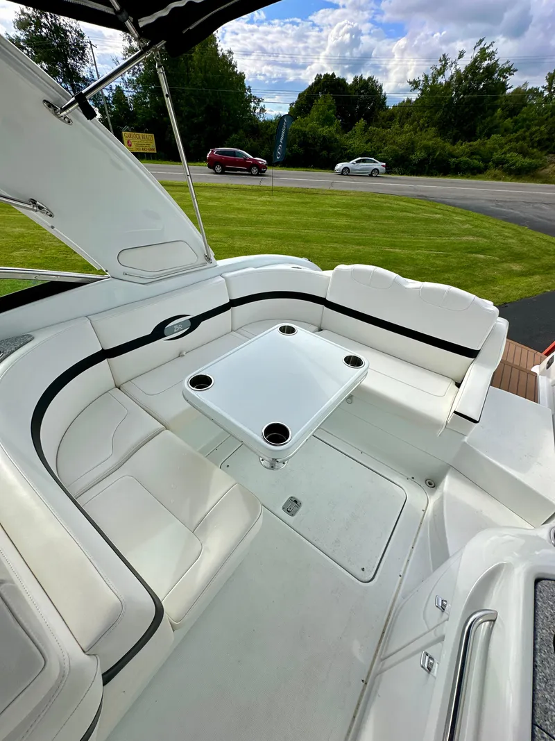 Slide: The Image of 2008 Formula 310 Bowrider interior with white seating and table, parked on grass. - 2