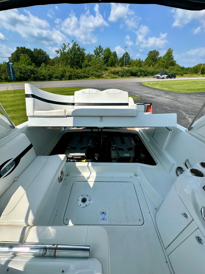 Slide: The Image of 2008 Formula 310 Bowrider boat interior with open engine compartment, under a clear blue sky. - 24