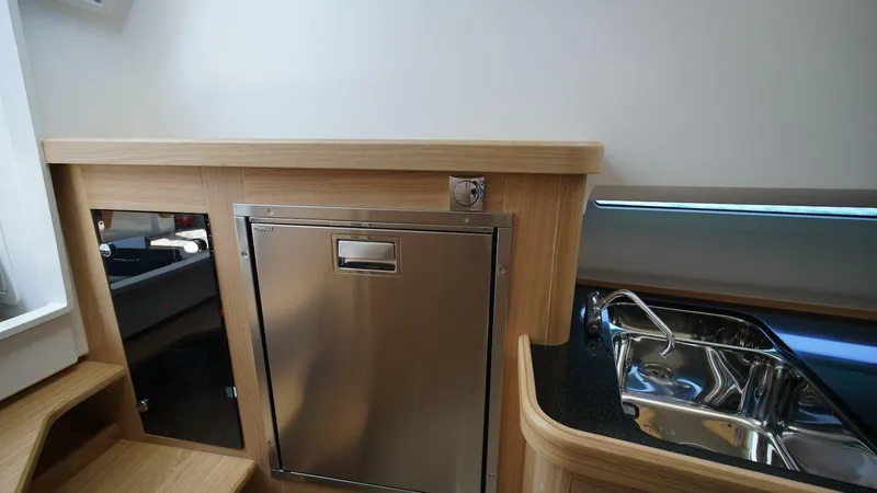 Slide: The Image of Interior of 2024 Nimbus Commuter 11 #082 featuring stainless steel fridge and sink. - 22