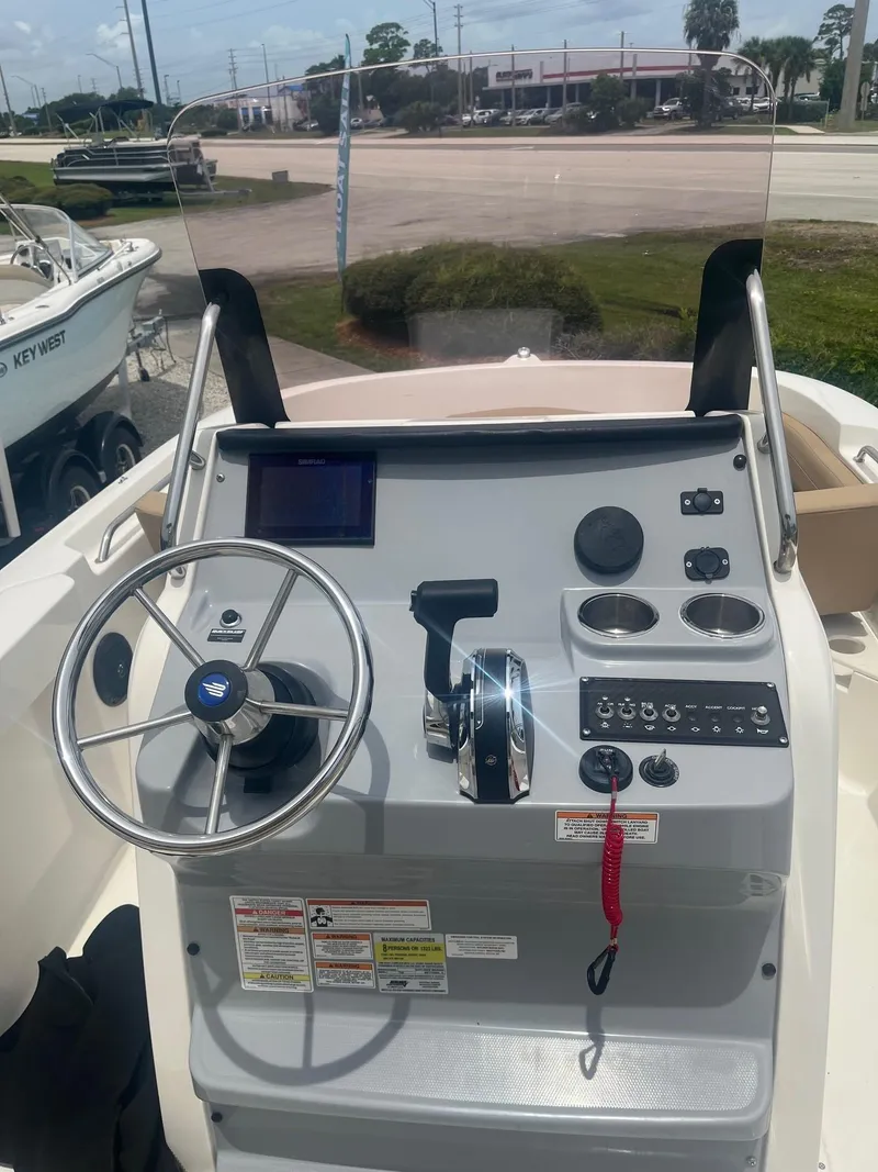 Slide: The Image of 2022 Bayliner Trophy T20CC boat console with steering wheel and control panel. - 7