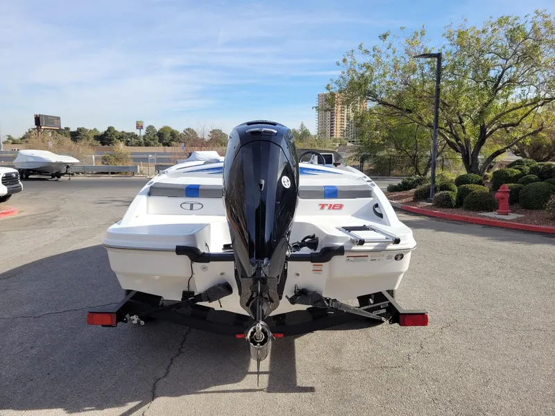 Slide: The Image of 2024 Tahoe T18 boat with outboard motor, parked outdoors on a sunny day. - 5