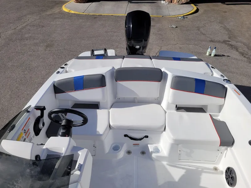 Slide: The Image of 2024 Tahoe T18 boat interior with seating and steering wheel, parked on pavement. - 7