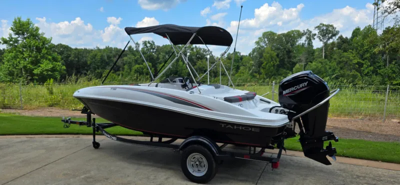 Slide: The Image of 2024 Tahoe T16 boat with Mercury engine on trailer, parked outdoors. - 1