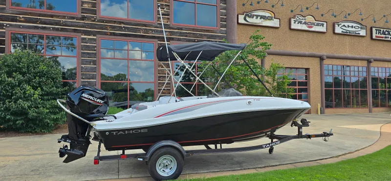Slide: The Image of 2024 Tahoe T16 boat on trailer outside dealership with branded signage. - 3