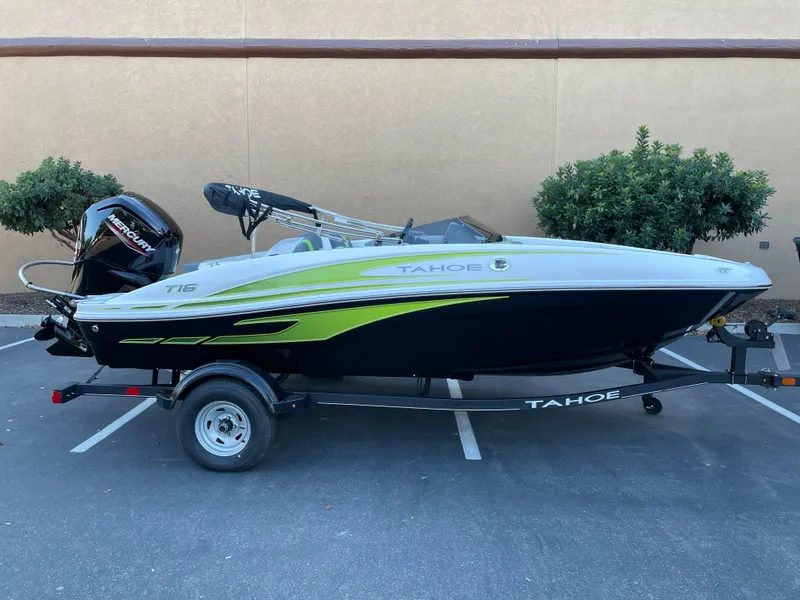 Slide: The Image of 2024 Tahoe T16 boat with trailer, parked outdoors, featuring sleek design and vibrant accents. - 0
