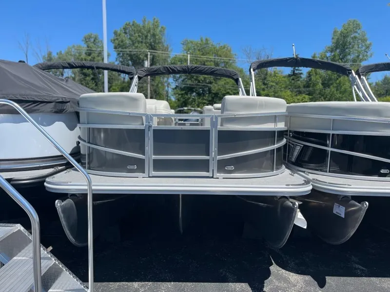 Slide: The Image of 2024 SunChaser Vista 20 LR pontoon boat on display in a marina. - 2