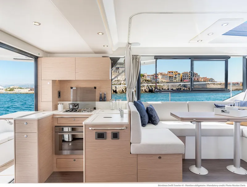 Slide: The Image of Interior of 2025 Beneteau Swift Trawler 41 Fly, featuring modern kitchen and dining area with ocean view. - 9